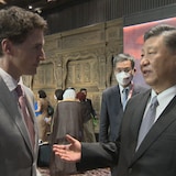 Justin Trudeau écoute parler Xi Jinping dans une salle.