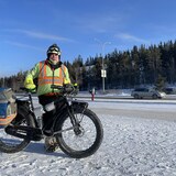 Paul Davis pose devant son vélo l'hiver. 