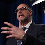Jean François Roberge gesticule devant un micro.