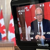 Le visage d'un homme apparaît sur un écran durant une conférence de presse.
