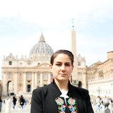 Une femme se tient debout sur la place Saint-Pierre, au Vatican.