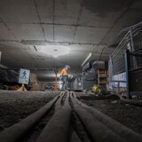 Un ouvrier marche dans le chantier de construction d'un tunnel.