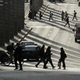 Des personnes circulent à pied, à vélo, en voiture et en autobus dans un quartier central de Montréal.