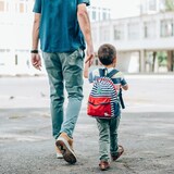 أب يرافق ابنه إلى المدرسة.