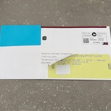 Une enveloppe avec un collant de renvoi à l'expéditeur est posée sur une table.