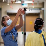 Una enfermera prepara un suero a ser inyectado.