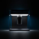 Une photo montrant l'ordinateur quantique Q System One d'IBM, un grand cube de verre contenant un cylindre chromé suspendu.