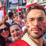 أشخاص يحملون أعلاما لبنانية.