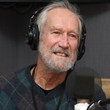 Serge Mongeau, souriant, avec un casque d'écoute sur les oreilles.