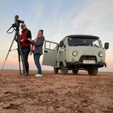 Tamara Alteresco et Alexey Sergeyev filmant dans un désert, près d'une caravane motorisée.