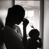 صورة ظلية لامرأة مع طفلها الصغير بين ذراعيها.