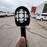La main d'un journaliste tenant un micro. 