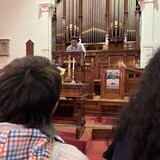 Manuel Rodriguez s'adresse au public dans une église. 