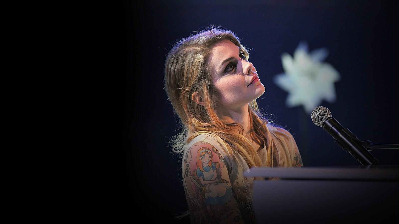 Coeur de pirate, au piano, regarde vers le ciel.