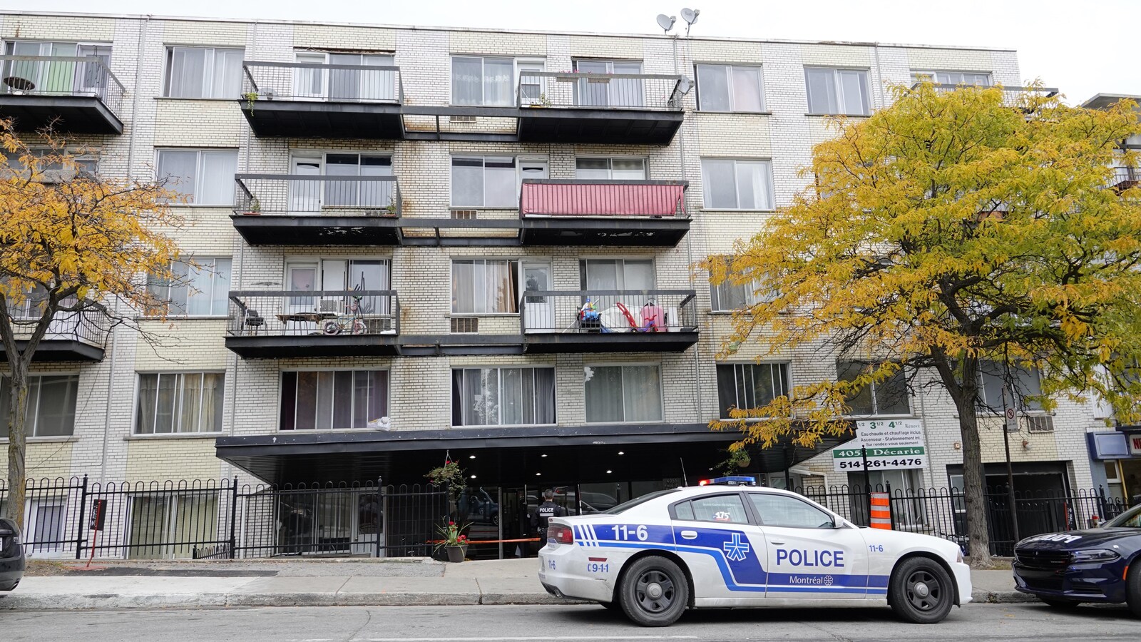 Une voiture de police garée devant l'immeuble de logements.