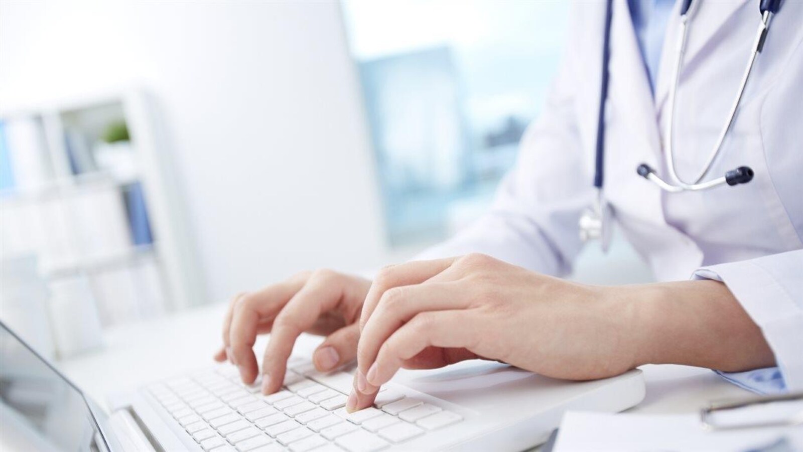 Une médecin tapant sur le clavier d'un ordinateur