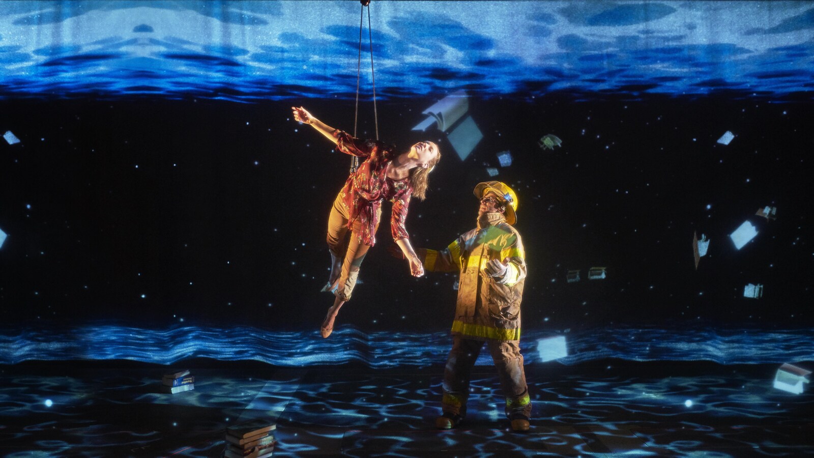 Des acrobates livrent une prestation, baignés dans un univers de projections oniriques.