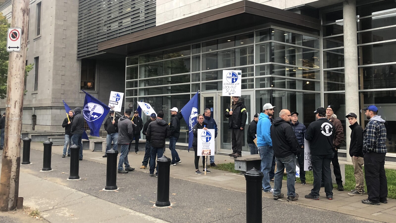 Gens avec des pancartes devant le palais de justice