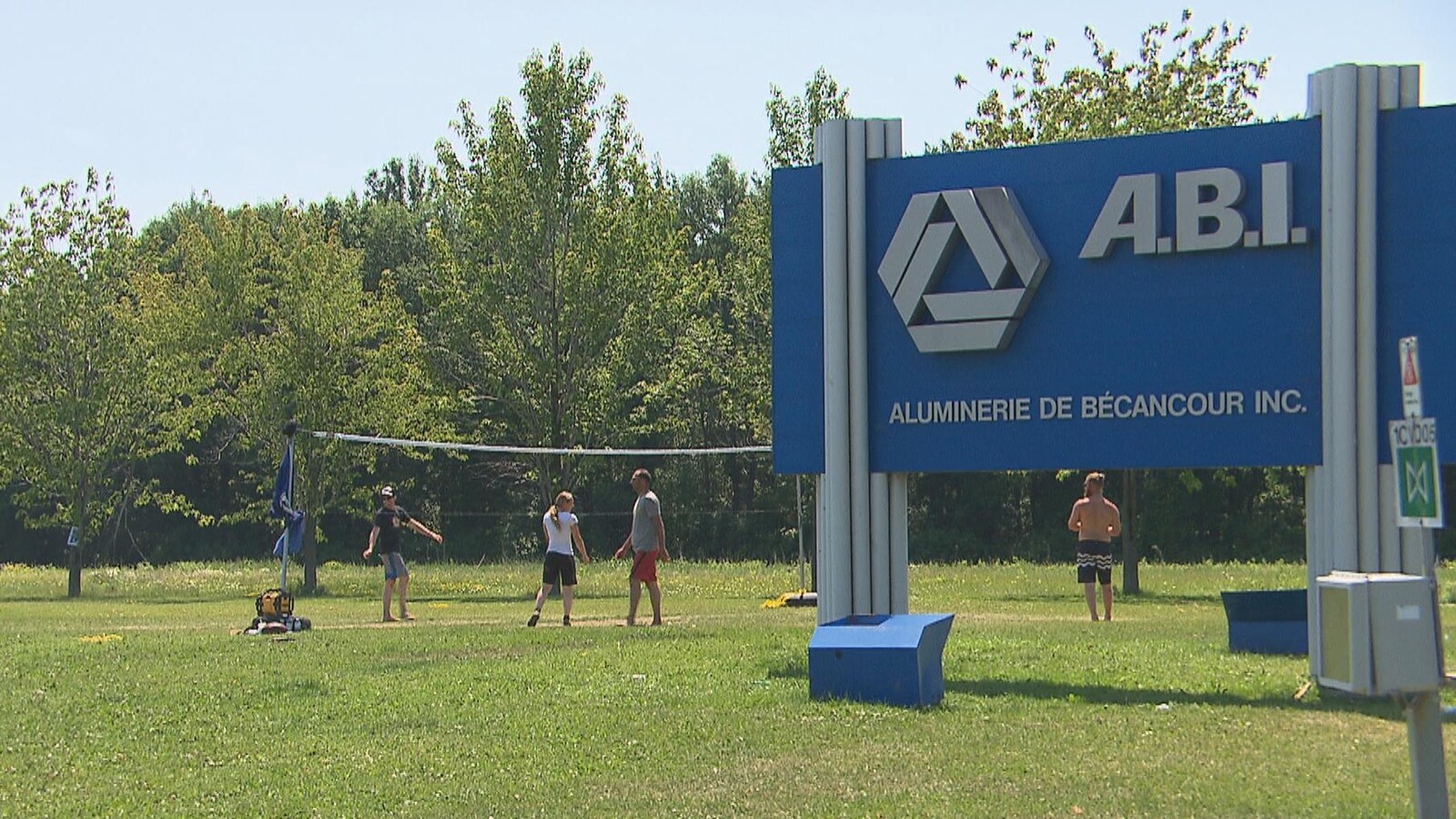 Les syndiqués jouent au volleyball sur le gazon du terrain de l'ABI, à Bécancour, près de l'affiche extérieure