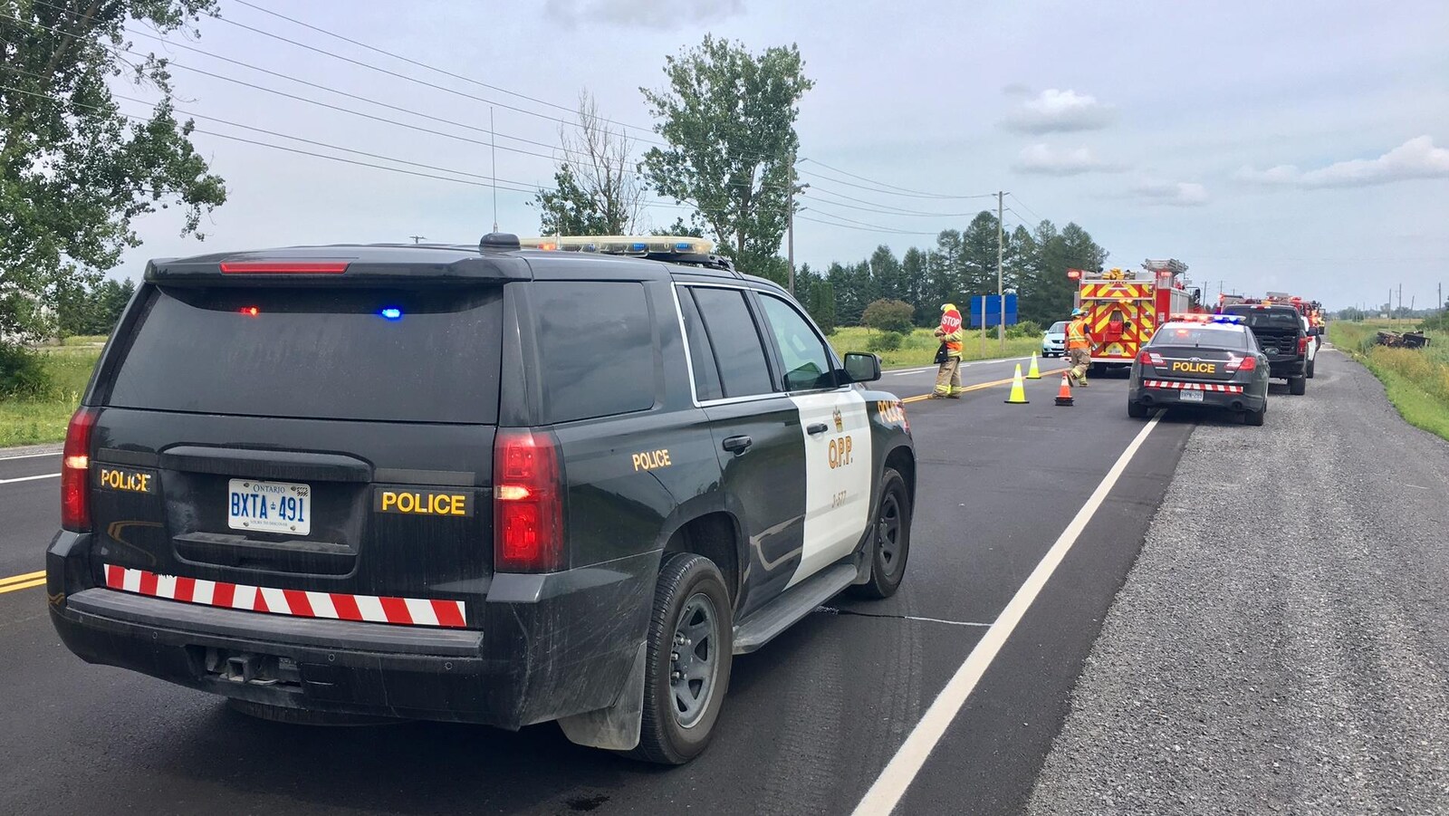 Des voitures de la Police provinciale de l'Ontario et un camion de pompiers sur les lieux d'un accident.