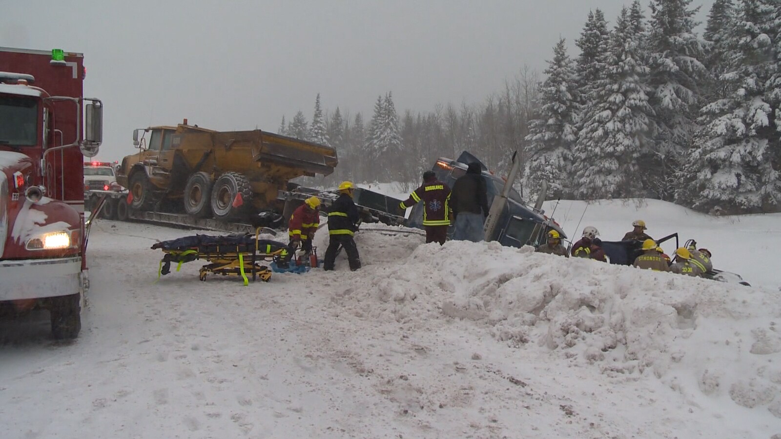 Des pompiers s'activent autour d'un camion, renversé dans le fossé de la route 185.