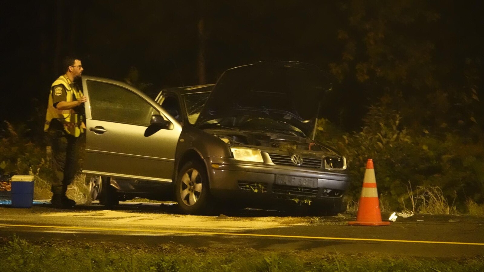 Une voiture accidentée et un policier qui l'observe.