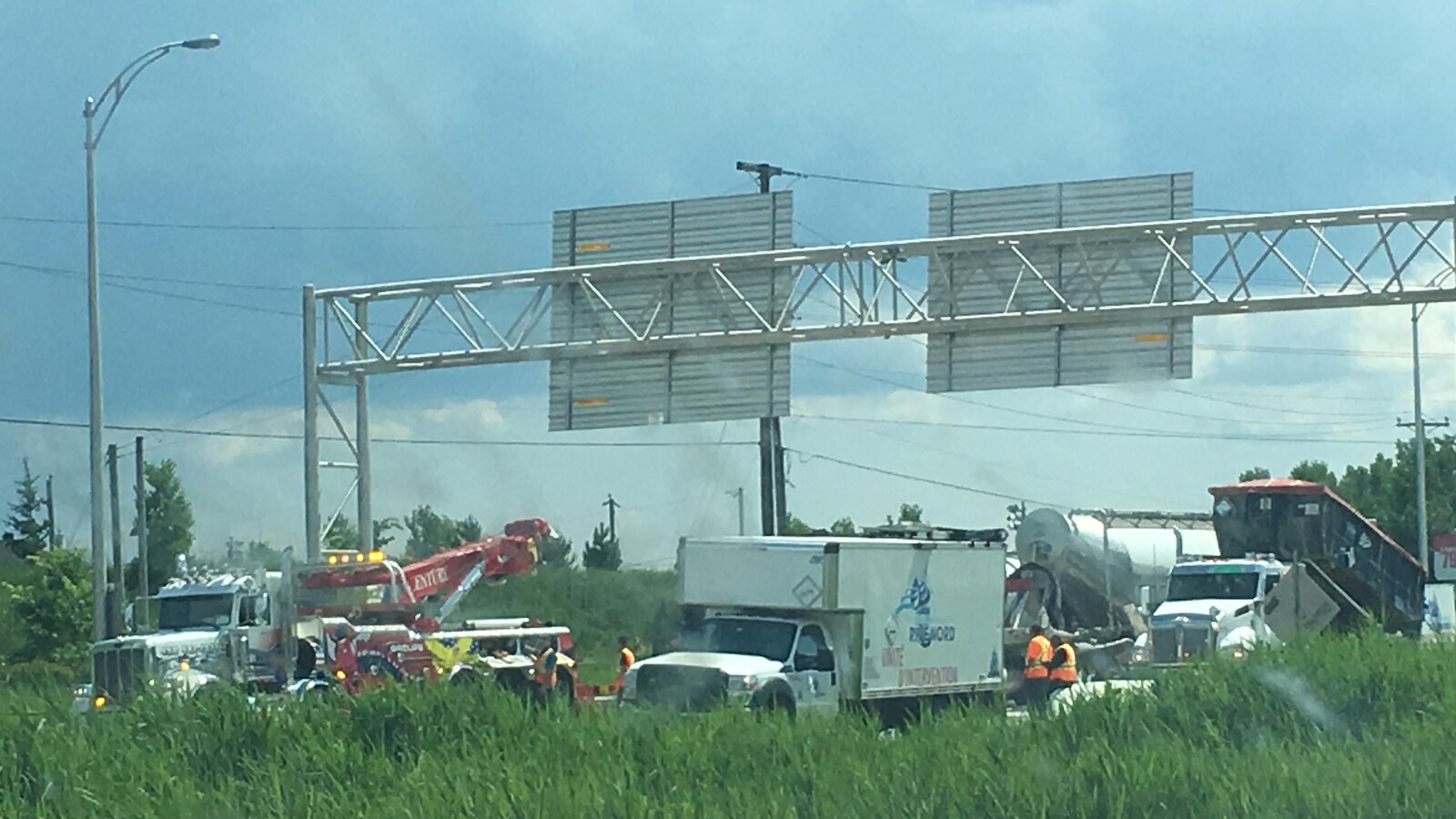 Plusieurs camions, une grue et des employés de la voirie