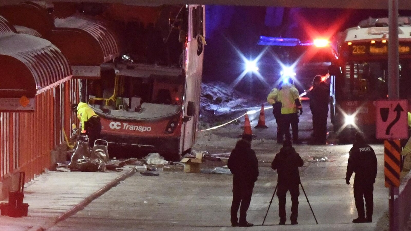 Des gens en uniforme devant un autobus accidenté