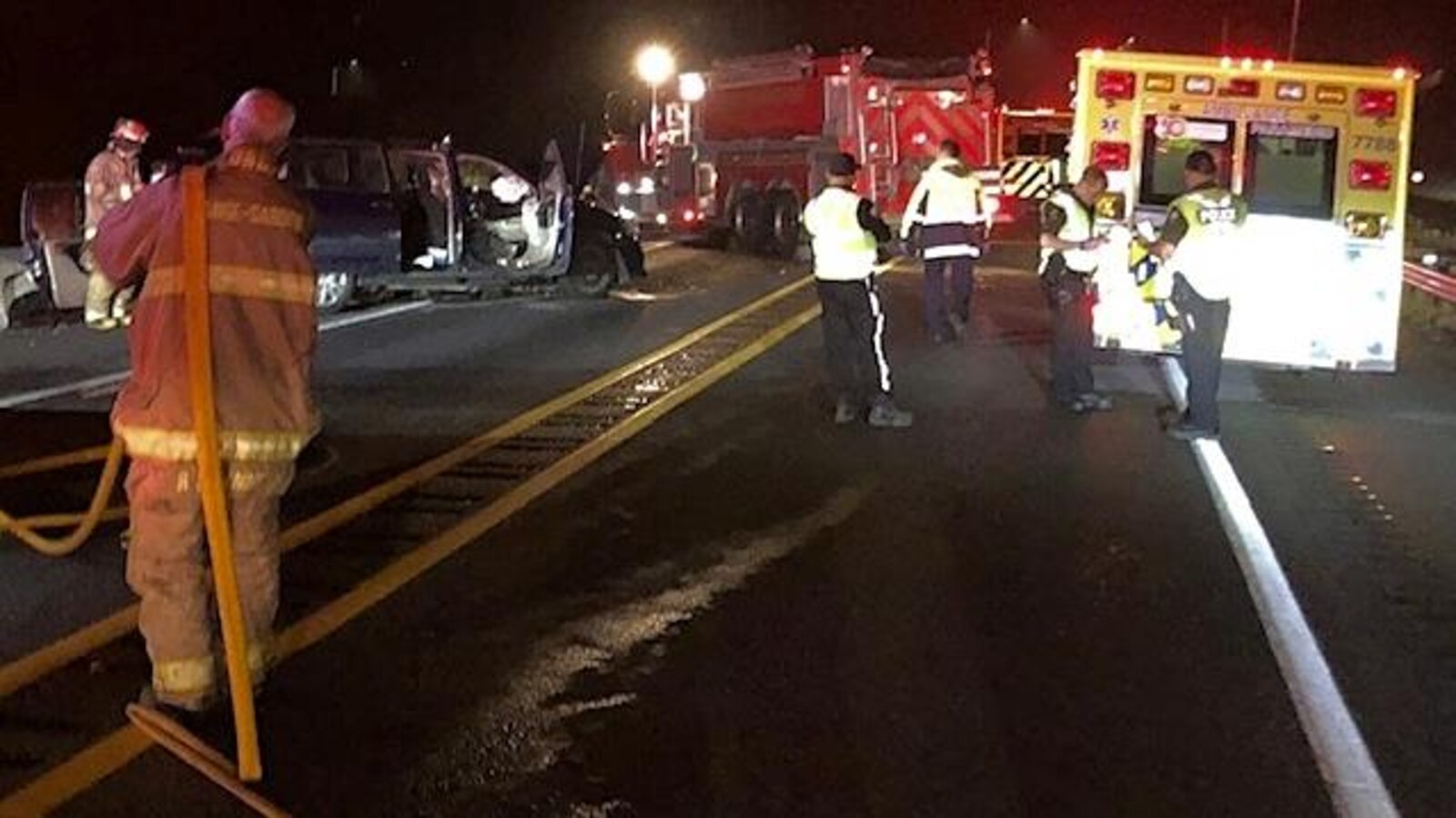 Des pompiers, ambulanciers et policiers entourent un des véhicules accidentés.