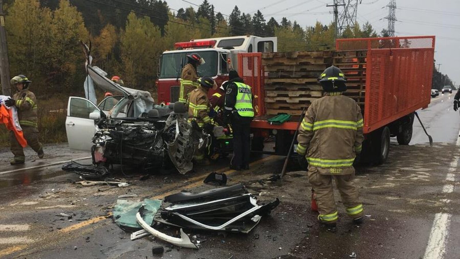 Des pompiers s'affairent autour du véhicule accidenté.