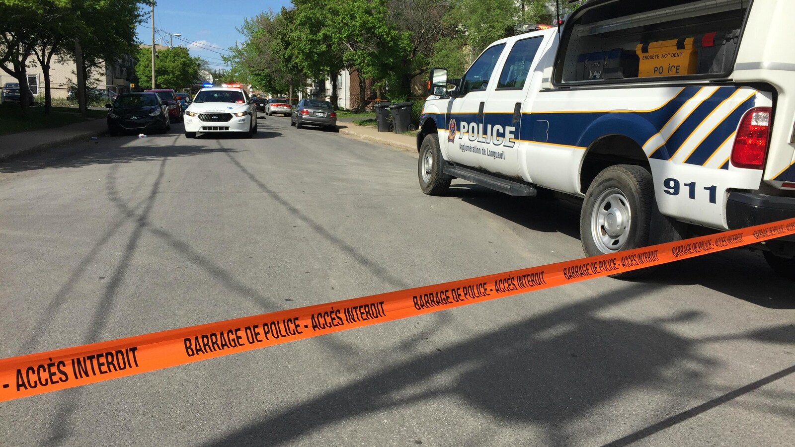 Deux voitures de police barrent la rue Goyette.