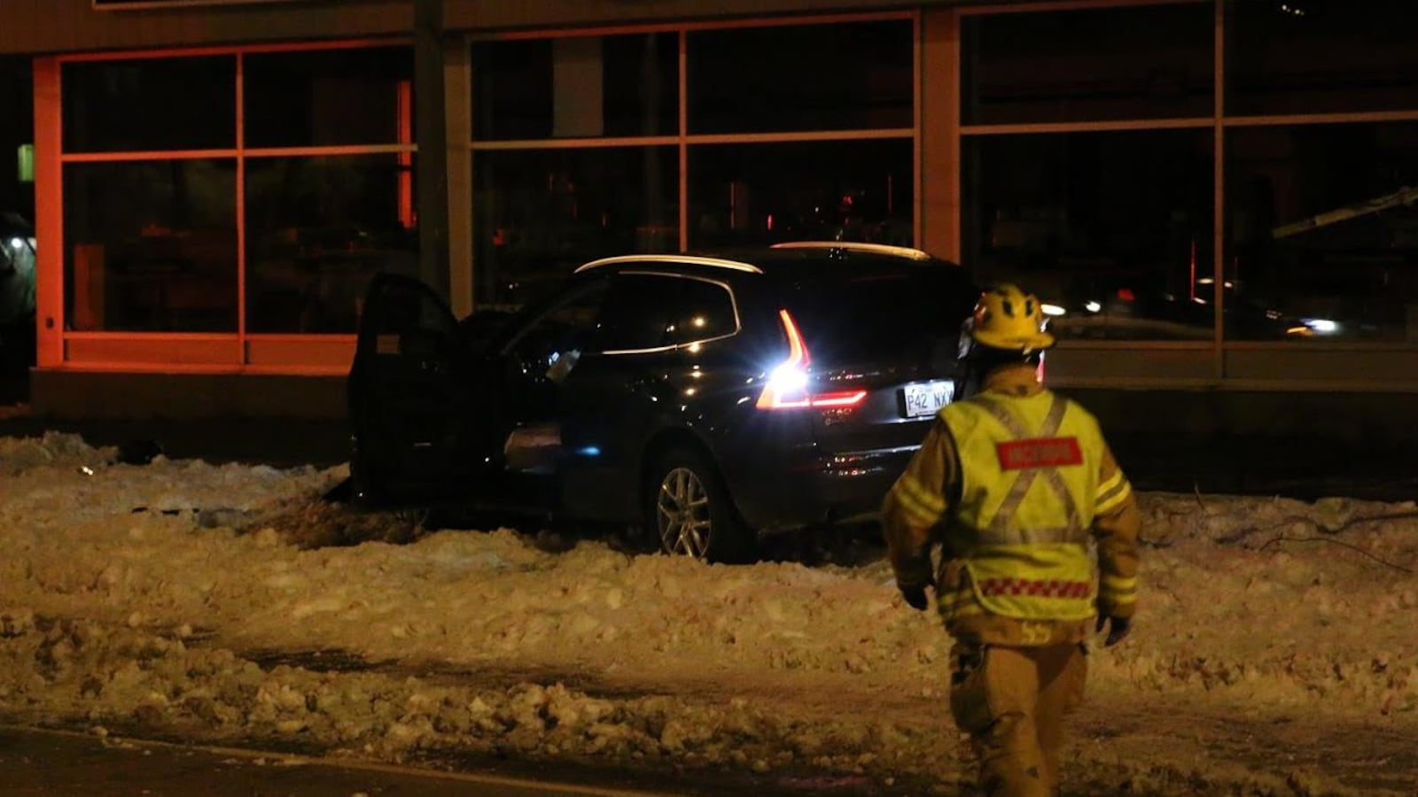 Un pompier s'approche de la voiture immobilisée, la porte ouverte