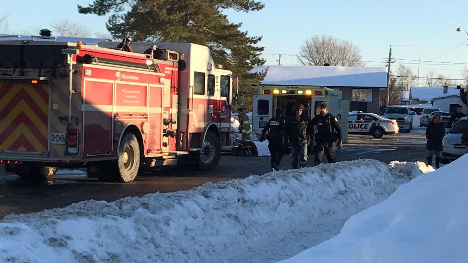 La photo montre un camion de pompier, des policiers et une voiture de police fermant une rue, afin de permettre aux secouristes de faire leur travail.