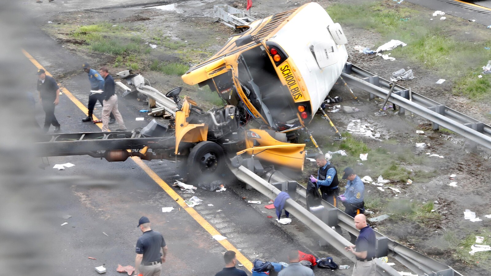 Un autobus scolaire est couché sur le côté et lourdement abîmé.