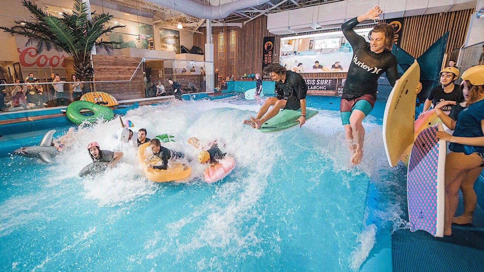 Six garçons surfent sur une vague artificielle.