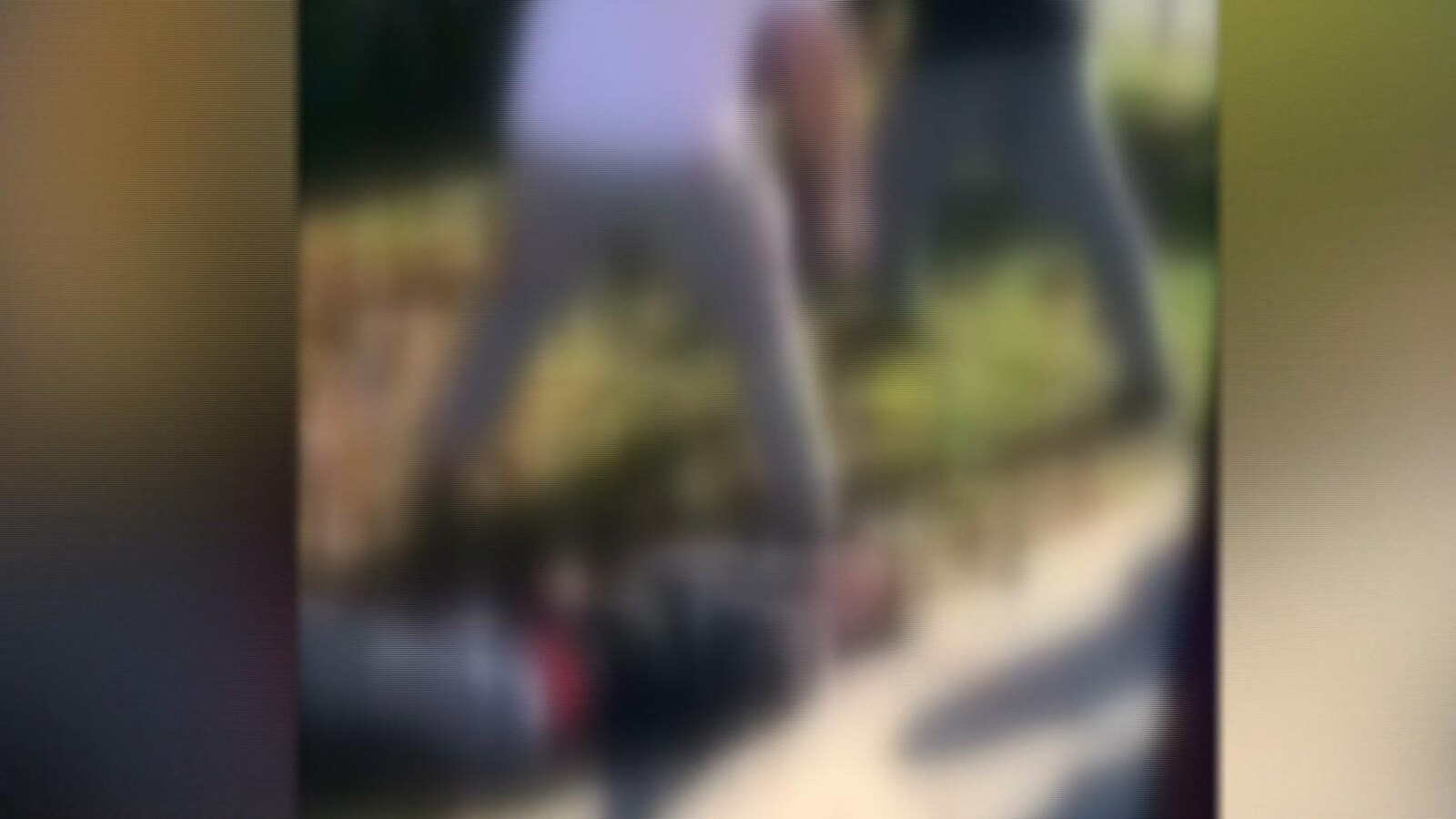 Une capture d'écran d'une vidéo où l'on peut distinguer un élève au chandail blanc qui piétine un élève au sol.