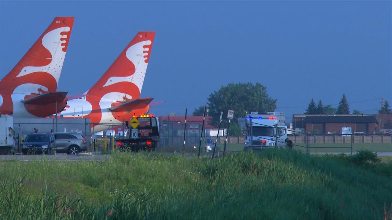 Des véhicules de police près d'un tarmac d'avions.