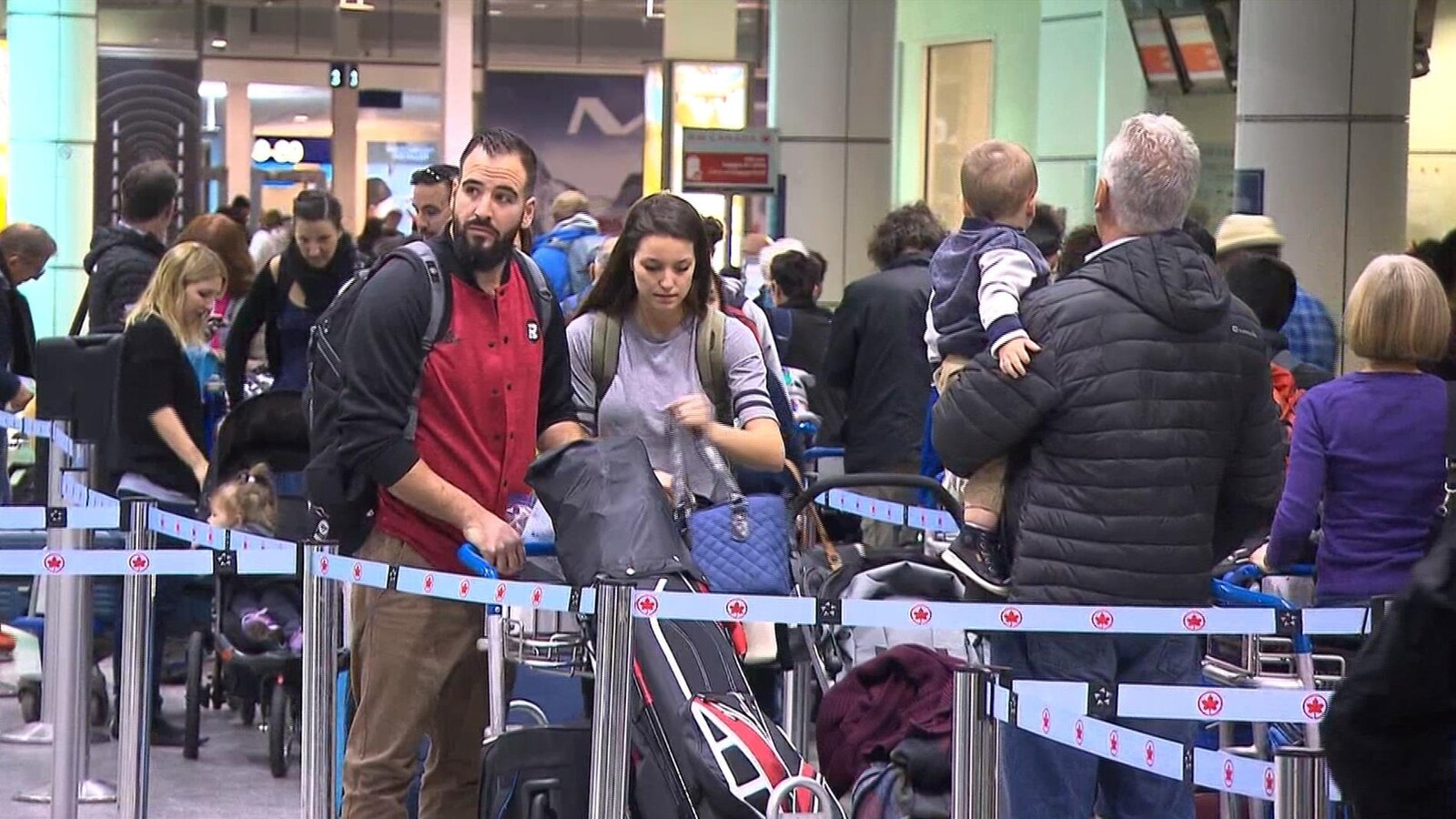 Plusieurs personnes font la file à l'aéroport.