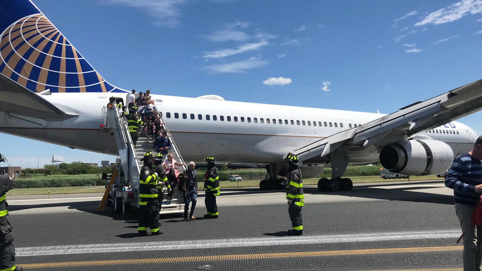 Le personnel d'urgence aide les passagers à descendre d'un avion après une sortie de piste d’un appareil de United Airlines à l'aéroport international Newark Liberty le samedi 15 juin 2019 à Newark.