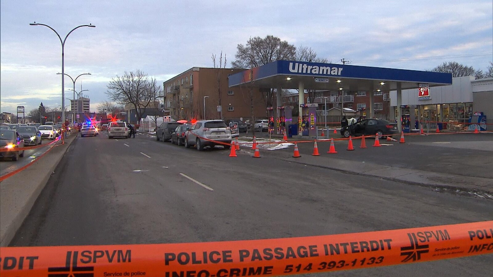 Vue de la scène avec voitures de police devant une station-service.