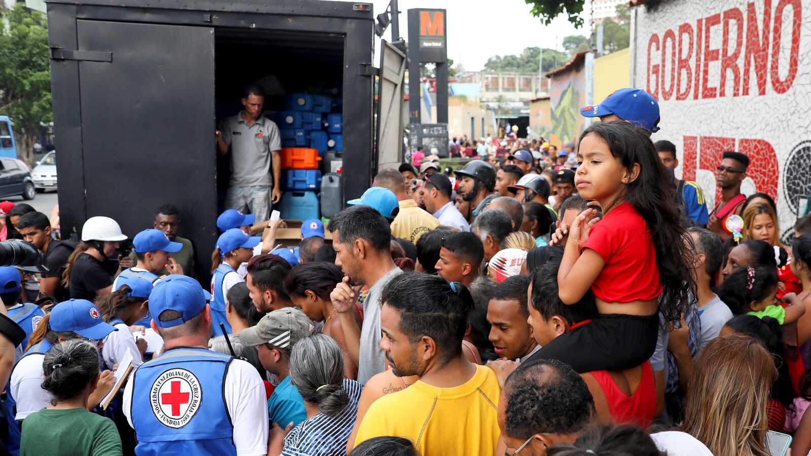 Des travailleurs humanitaires de la Croix-Rouge vénézuélienne distribuent de l'aide humanitaire sous forme de conteneurs d'eau et de pilules de purification de l'eau dans le quartier Agua Salud à Caracas le 16 avril 2019.