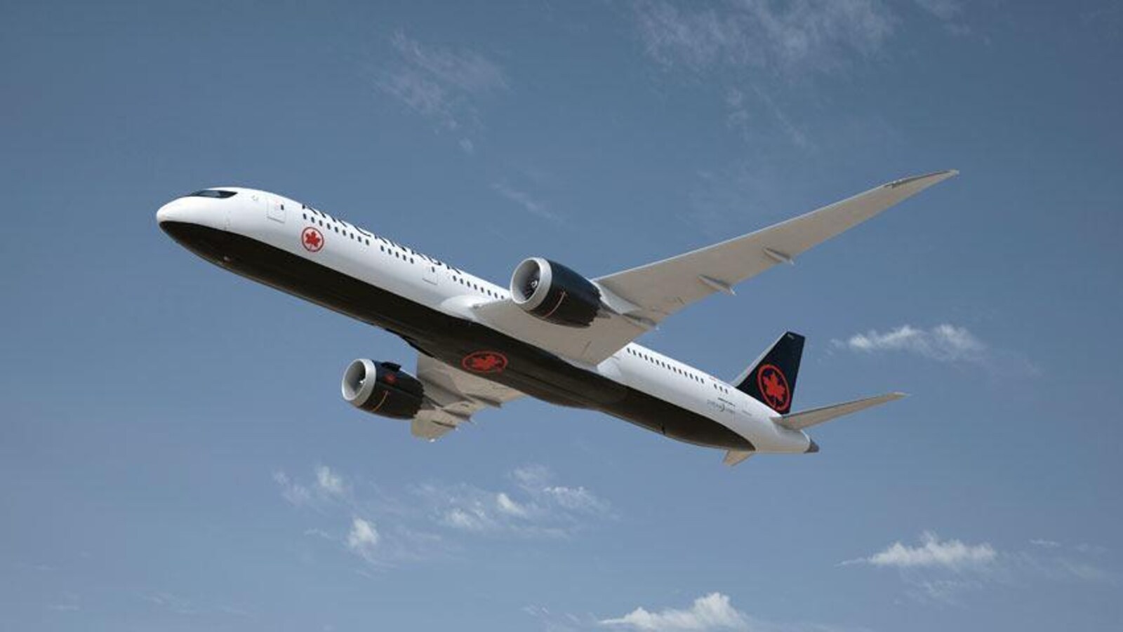 Un avion peint aux couleurs d'Air Canada (noir et rouge) en plein vol.