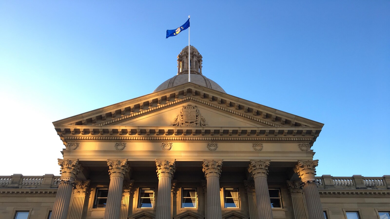Un rayon de soleil frappe le fronton de l'assemblée albertaine.