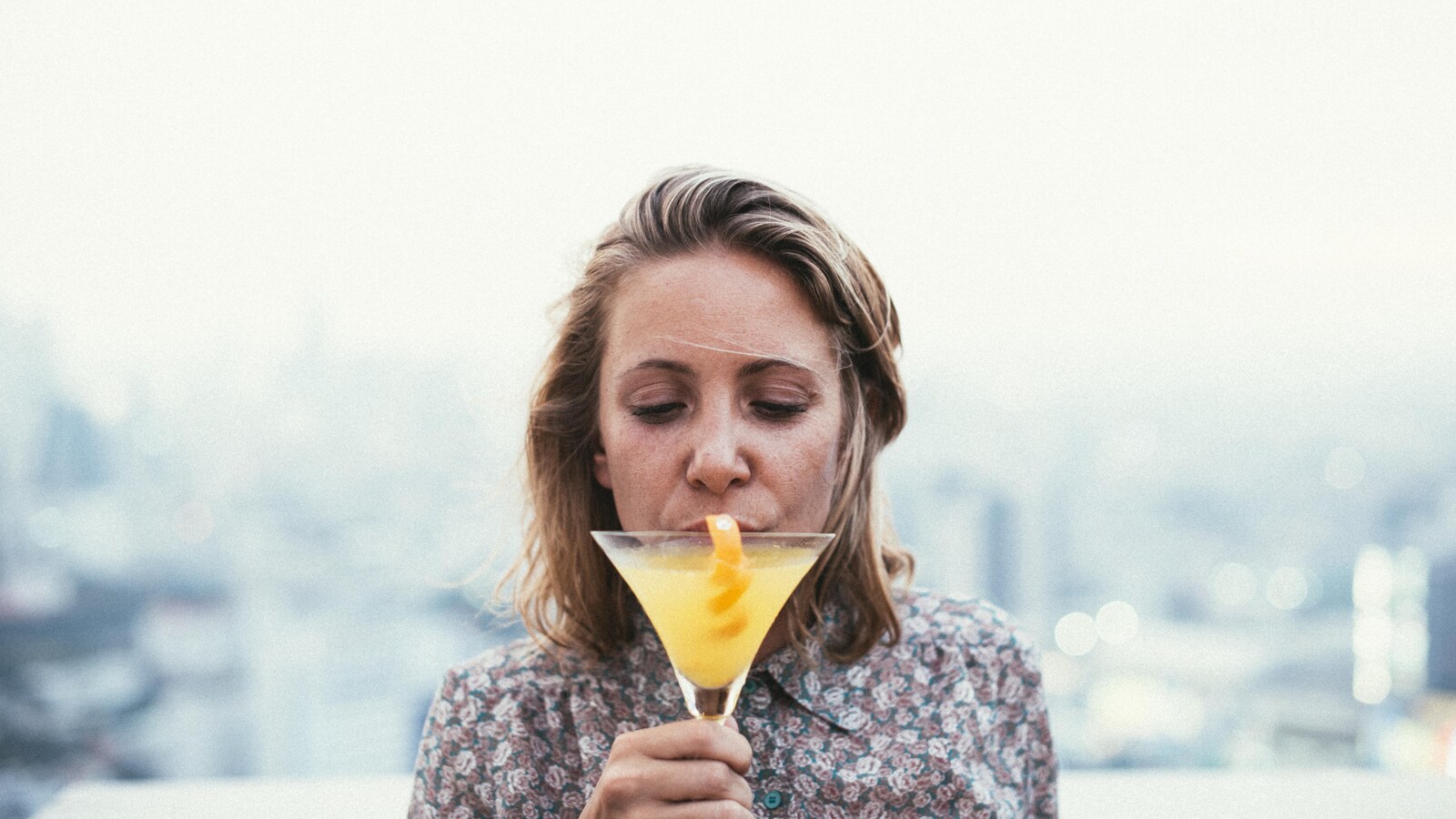 Une femme boit une boisson alcoolisée.
