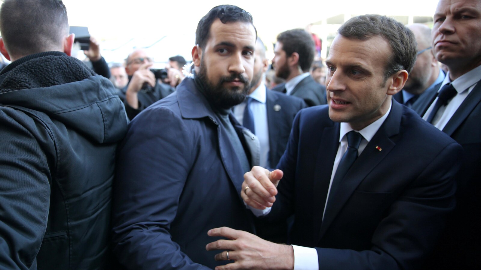 Alexandre Benalla met son bras devant Emmanuel Macron.