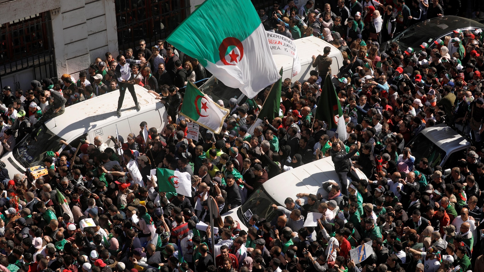 Des manifestants brandissant des drapeaux algériens.
