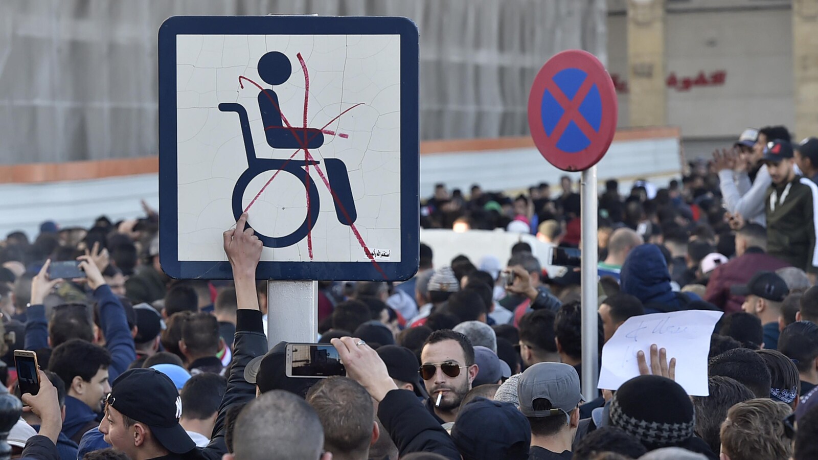 Un gros X rouge barre l'homme en chaise roulante sur la pancarte.