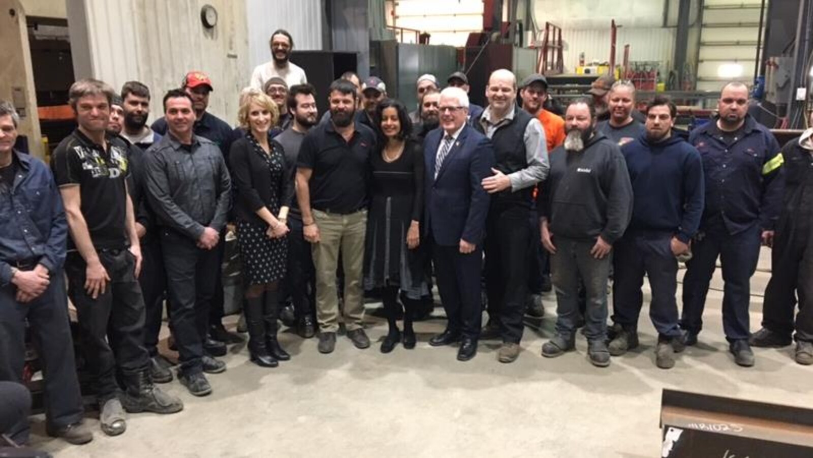 La ministre de l'Économie, Dominique Anglade, et le député de Dubuc, Serge Simard, entourés des dirigeants et travailleurs de l'usine Alma Soudure de Saint-Bruno