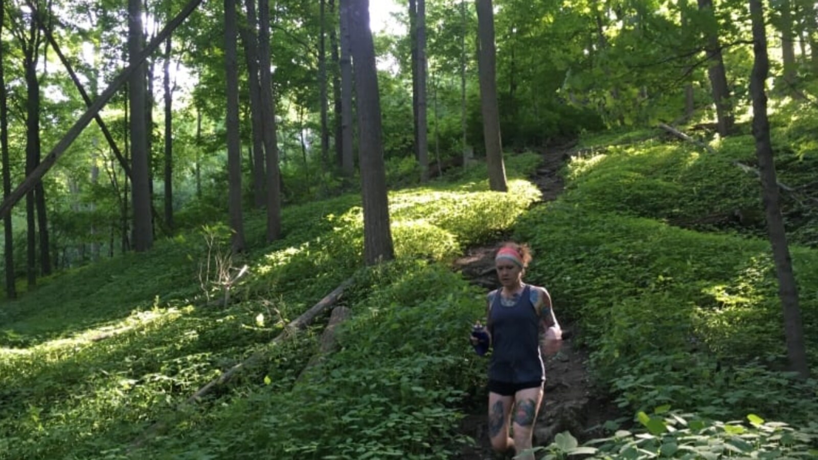Photo d'une femme qui court dans la forêt.