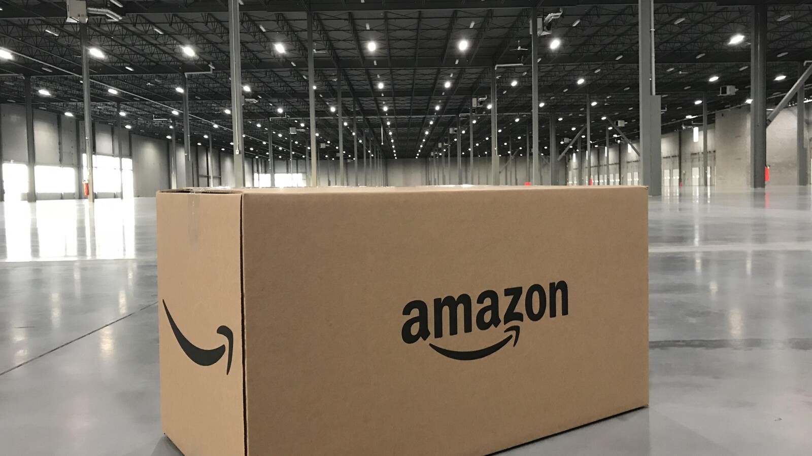Une boîte portant le logo d'Amazon posée sur le sol d'un entrepôt vide